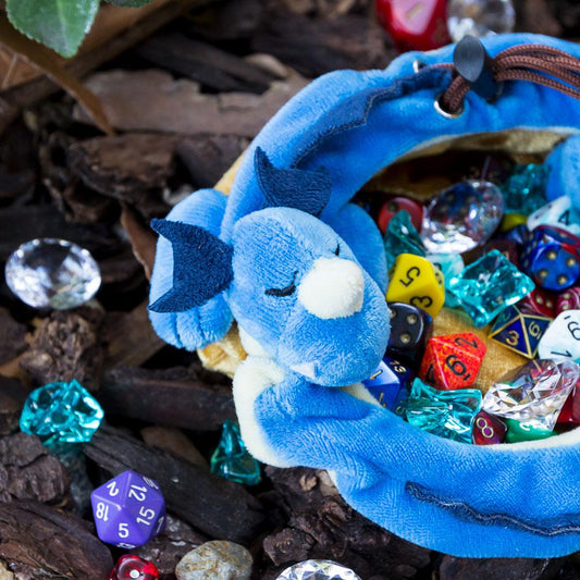 Blue sleeping dragon along the drawstring of a golden pouch dice bag