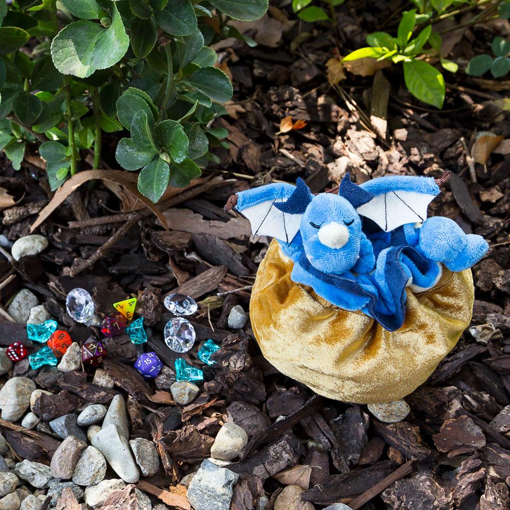 Blue sleeping dragon along the drawstring of a golden pouch dice bag