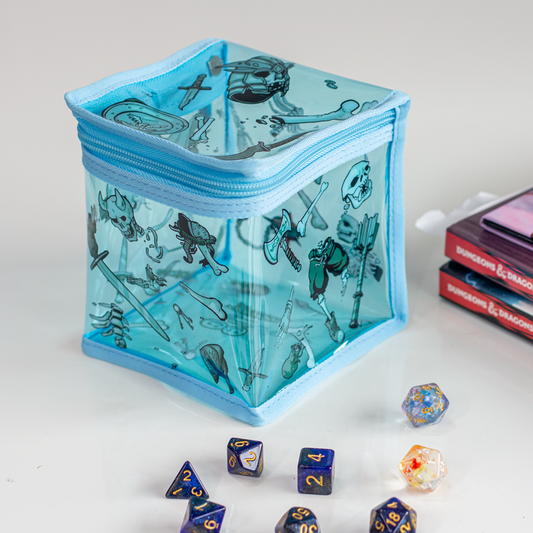 A cube shaped zippered box on display with polyhedral dice and DUNGEONS AND DRAGONS books. 